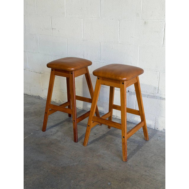 This pair of bar stools features a clean A-frame design with built-in footrests for comfortable seating. The minimalist...