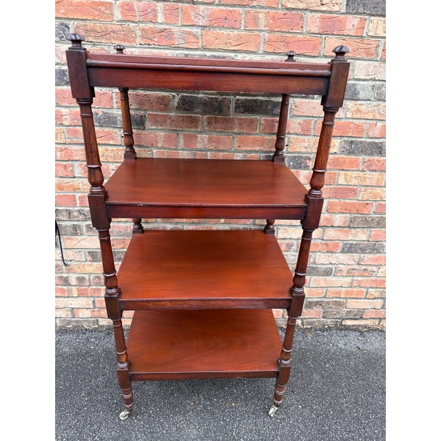 This is a beautiful mid 19th century English etagere with four shelves. Nicely turned legs resting on the original brass...