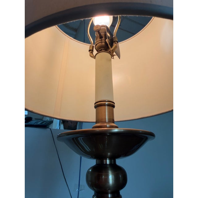 A Haig table lamp featuring a traditional candlestick design crafted from solid brass with an antique finish. The lamp is...