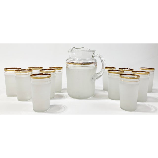 Vintage Mid-Century Modern pitcher and glassware set featuring large pitcher and 12 matching juice glasses. Each has gold...