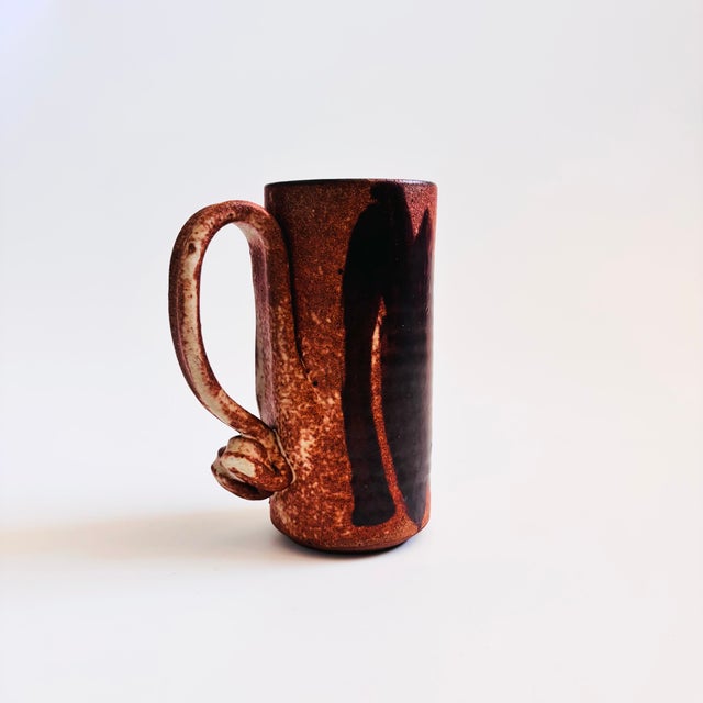 A vintage studio pottery mug. Lovely natural colored glazes in earthy reddish brown and gray. Features hand painted...