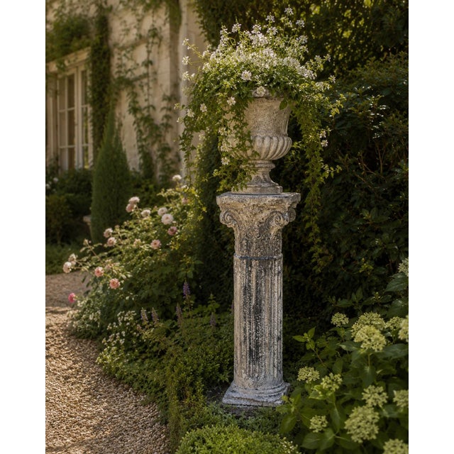 A weathered late-20th-century garden pedestal cast in concrete and modeled after a classical Corinthian column. Its...