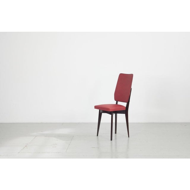 Kitchen chair with red synthetic leather cover from the 1960s. The beech wood was stained dark. The cover is still in very...