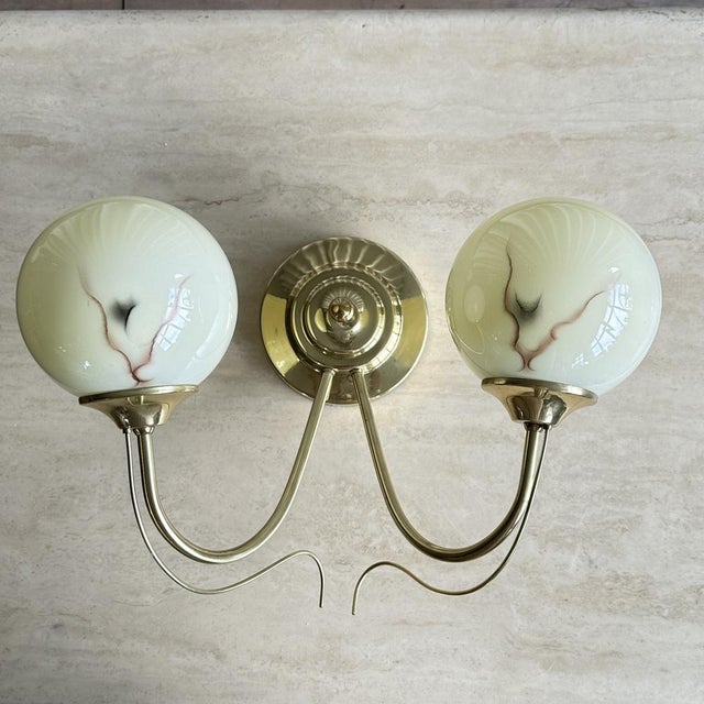 Beautiful and elegant art deco wall lamp with marble pattern opaline glass shade and brass mounting and arms from the...