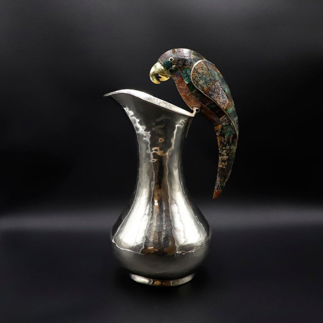 Circa 1960. We offer this Big Size Mexican Silver Plated and malachite pitcher sporting an amazing handle in a parrot...