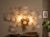 Large 1980s wall sconce featuring 20 delicate Murano glass flowers set on a golden brass structure. It accommodates 3...