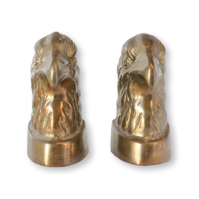 Pair of vintage brass eagle bookends in a sculptural figural form, featuring stylized eagle heads with detailed feathering...