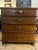 Handsome four drawer, chest clad in tool leather with brass hardware and a faux steamer trunk motif. Signed Theodore...