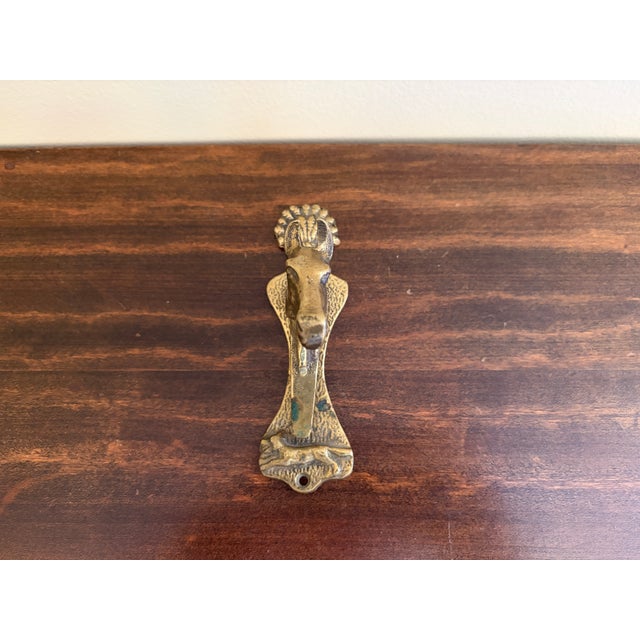 A characterful vintage English door knocker cast in brass and modeled as a horse’s head emerging from a tapered backplate....