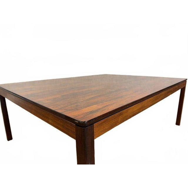 Elegant Danish Modern rosewood coffee table featuring a rich, warm brown finish and striking grain patterns across its...