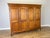 A handsome Vintage French Louis wardrobe in Oak, featuring four panelled doors, an elegant moulded cornice and gracefully...