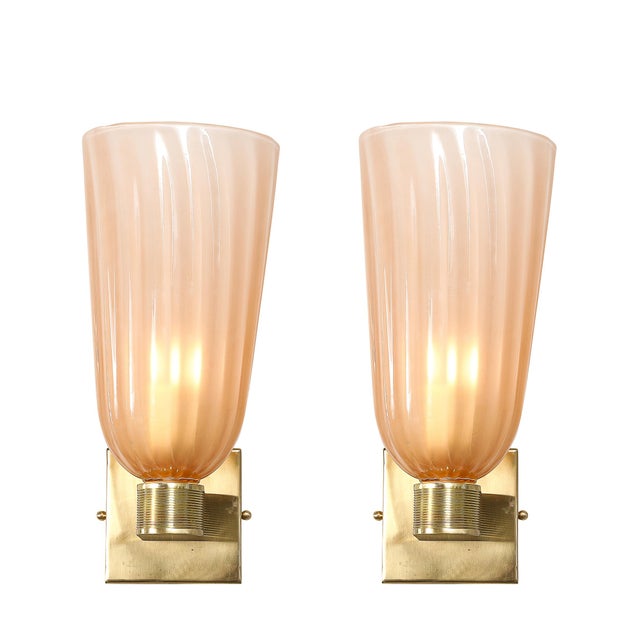 This pair of modernist hand-blown Murano fluted glass sconces in smoked rose, accented with brass fittings, is an...