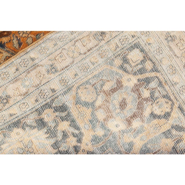 An early 20th century Persian Tabriz antique rug, the abrashed caramel field with a flowering vinery, palmette and...