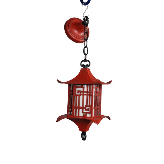 Circa mid-20th century red metal single light hanging lantern/pendant light. Pagoda style lantern with a pierced...