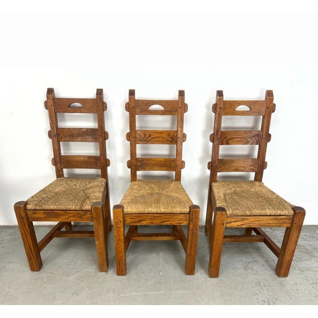 Set of six French oak dining chairs featuring tall backs and hand-woven rush seats.