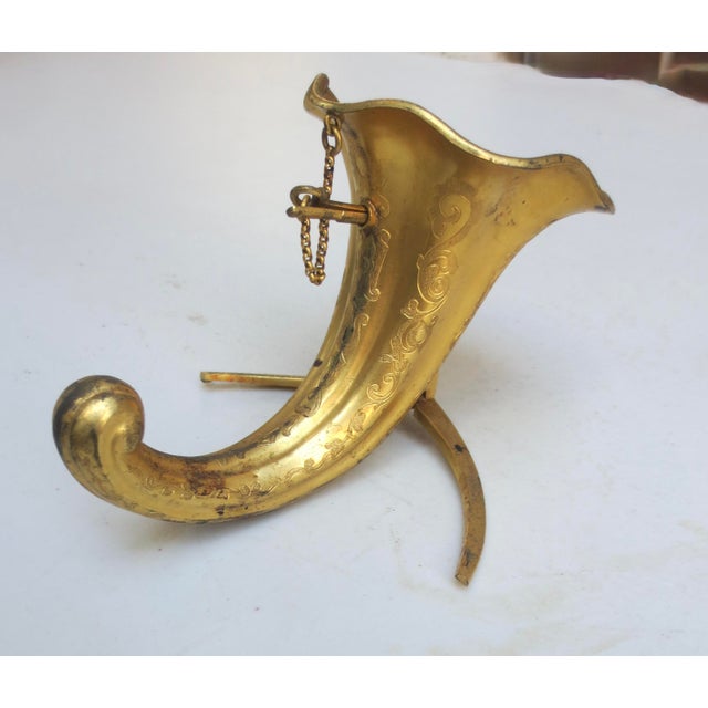 Brass tripod bouquet holder, aka as a "tussie-mussie" holder, featuring a cornucopia or horn of plenty design. A brass-...