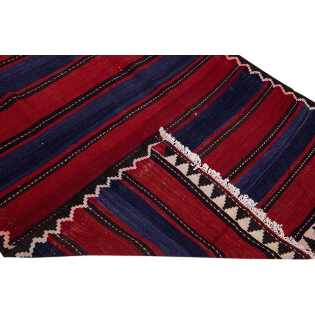 Beautiful vintage Turkish Kilim hand-knotted wool rug with a red field. This piece has multicolor accents in an all-over...