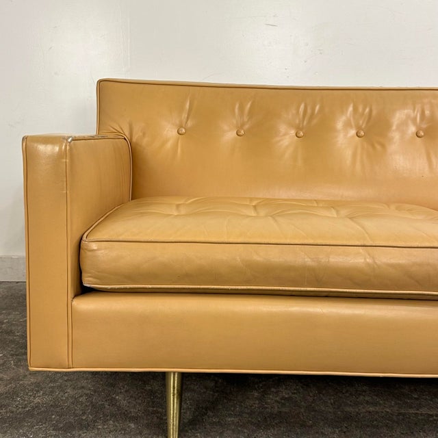 Mid Century Modern sofa by Edward Wormley for Dunbar Furniture. The sofa features a butterscotch tan leather with button...