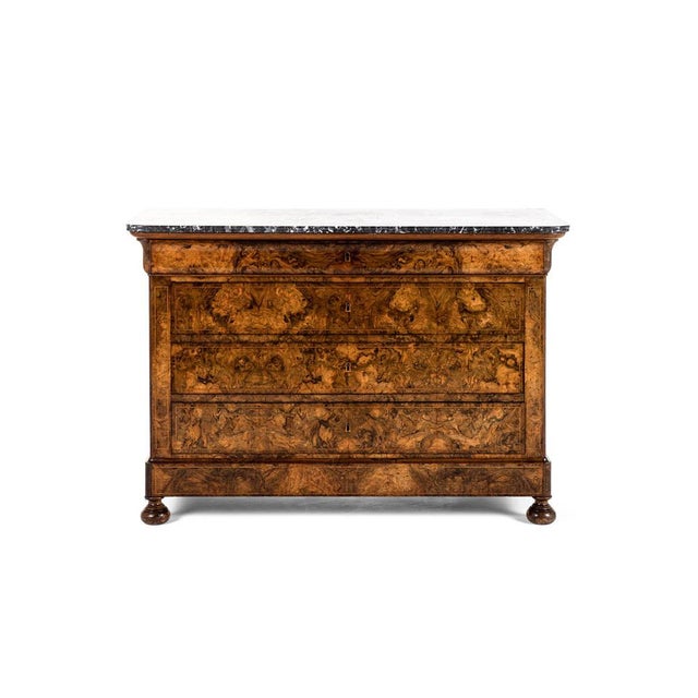 A substantial continental chest of drawers or commode in burr walnut with a gently over sailing original marble top. The...