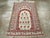 A vintage Indian Cotton Agra throw rug. A columnar pointed arch encloses 13 identical flowering plants and is itself...