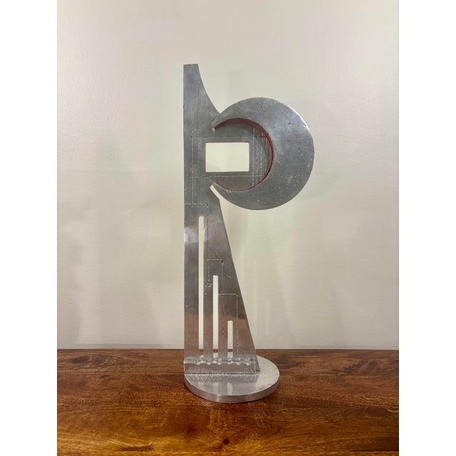 Created in 1977, this signed abstract sculpture by Beni Winkler brings together a broad crescent, architectural vertical...