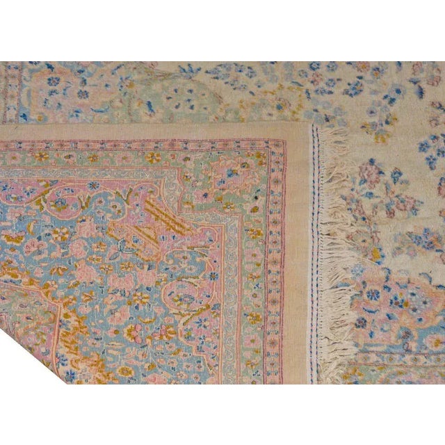 A massive early 20th century Persian Kirman rug with a wonderful all-over floral and leaf pattern woven in pink, light...