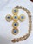 Vintage Alexis Kirk necklace featuring sculptural gold‑tone sunburst elements set with faceted blue stones and bright,...
