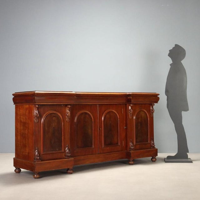Victorian sideboard crafted in mahogany, featuring an elegant design with a broken front and projecting side blocks. The...