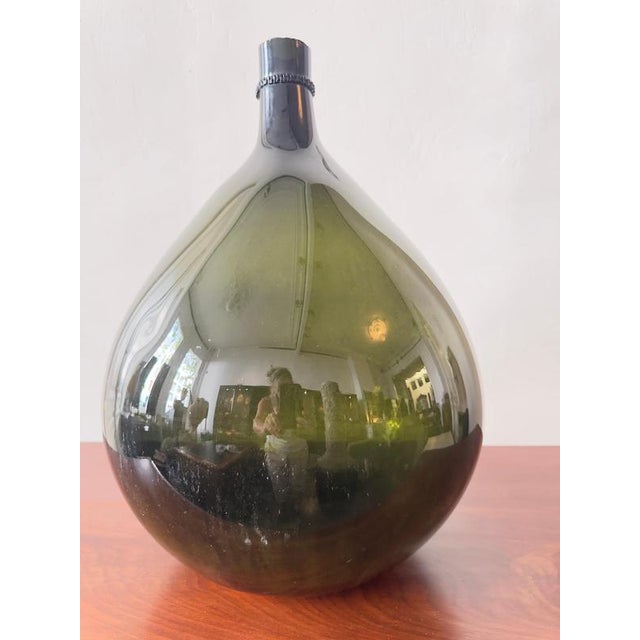 An exceptional and scarce 19th-century dark olive green glass bottle, hand-crafted in the distinctive "bladder onion"...