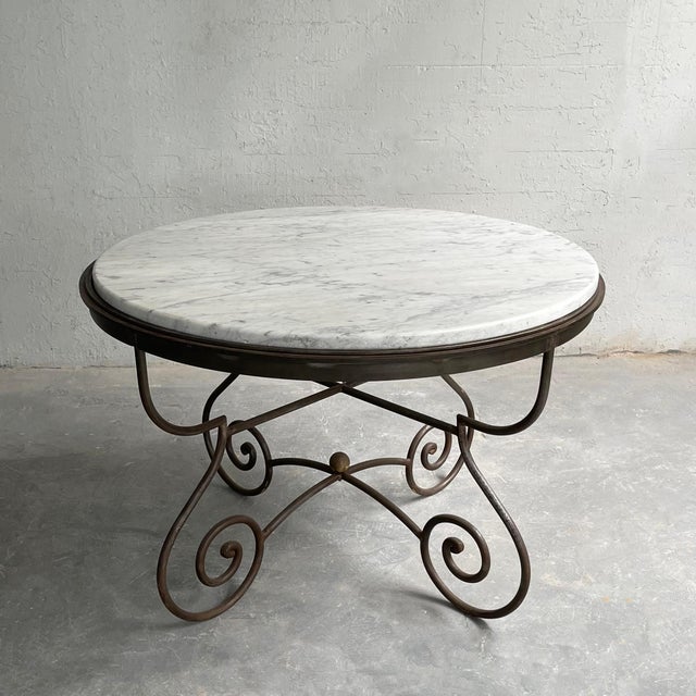 This impressive craftsman made Hollywood Regency, round marble dining or center table with a decorative steel base is...