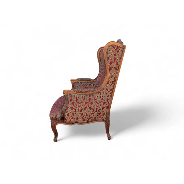 An elegant Louis XV-style Bergère armchair, featuring a refined hand-carved wooden frame, cabriole legs, and sculpted...