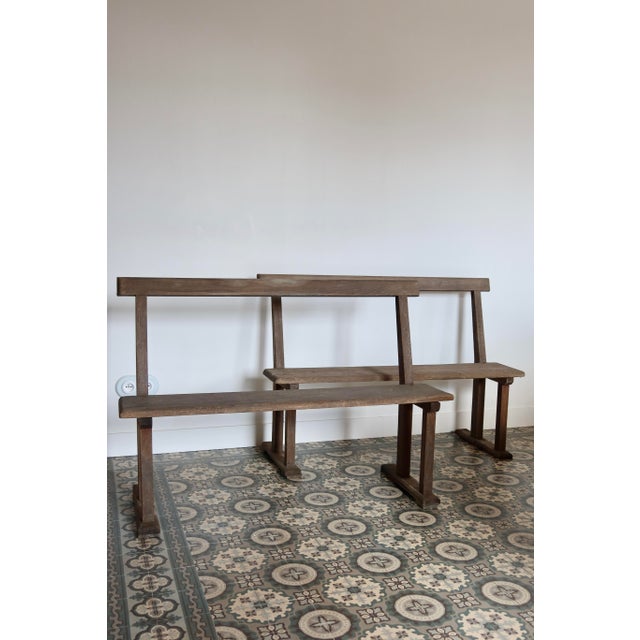 Pair of large antique wooden church pews, with straight backs and simple legs typical of chapel furniture. Their simple...