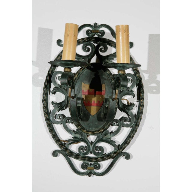Pair of French double arm cast iron sconces with heraldic imagery. Matching Ceiling Chandelier also listed.