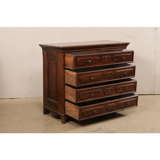 An Italian carved walnut chest of drawers from the 18th century. This antique cassettiera (chest of drawers) from Italy...