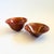 A set of 2 vintage studio pottery nesting bowls. Reddish glaze. Each is signed on the bottom. Overall measures 6.75"W x...