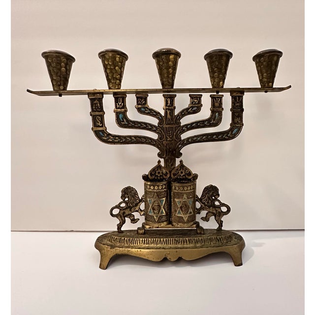 A beautifully crafted vintage brass menorah featuring intricate detailing and symbolic Judaic motifs. The piece includes...