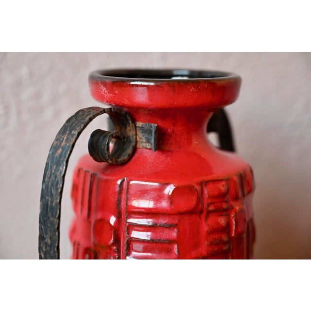 Bright red and proudly displayed in its black iron frame, this is a truly original German vase from the 1960s. It embodies...