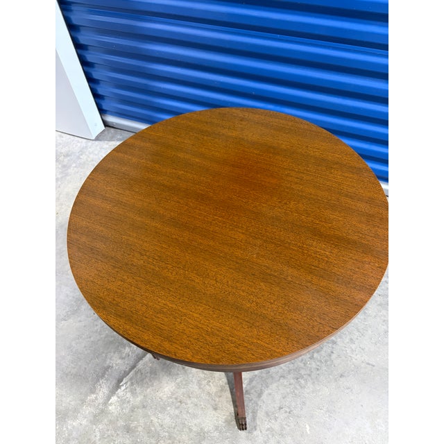 Classis vintage pedestal side table by Mersman, featuring a round mahogany-toned top, turned central pedestal and elegant...