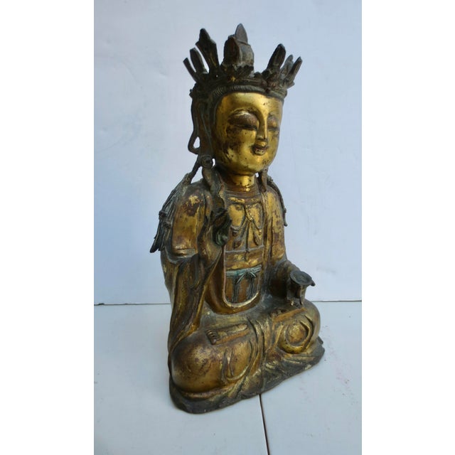 Antique Ming Gilt Bronze Kuan Yin. Crown and seated with robes and jewelry, holding a bowl and stem of lotus. Classic...