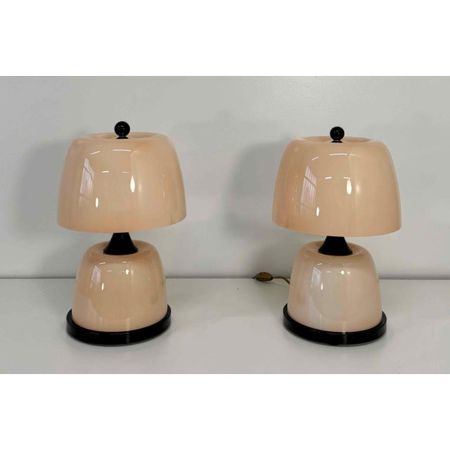 Elegant pair of Murano glass table lamps handcrafted in Italy in the 2000s. Each lamp features a refined pink glass body...