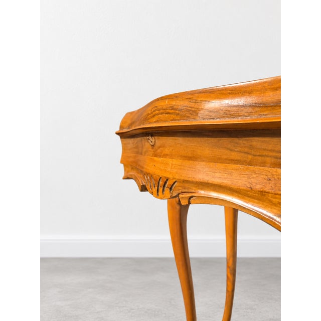 Elegant vintage wooden coffee table, estimated to have been produced around 1960, featuring arched legs, contoured...