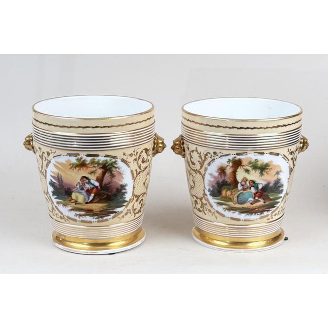 Pair 19th c. French Paris porcelain cachepot planters with lion mask handles in the Empire taste. Each decorated with...