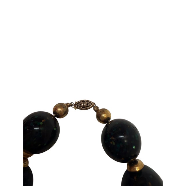 This amazing dark green confetti beaded choker with gold-tone accents also has a gold decorative clasp. The beads are...