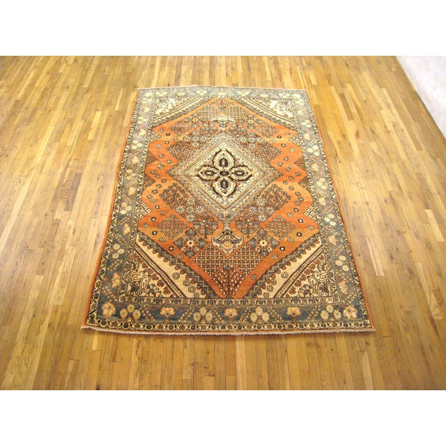A consigned vintage Persian Baktiari oriental rug, size 8'0" x 5'6", circa 1940. This brilliant hand-woven wool carpet...