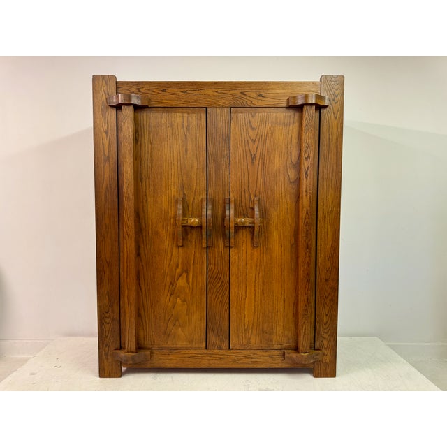 Vintage Belgian cupboard or wardrobe from the 1960s. The piece is crafted from rich, warm-toned oak, showcasing a...