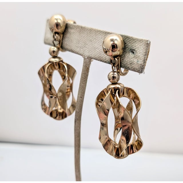 Rare 1955 goldtone round domed top with hand formed wavy "ribbons" coming together to form a drop clip earrings. Marked...