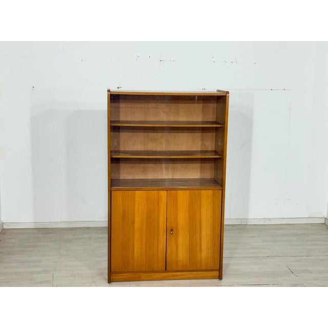 Beautiful vintage display cabinet from the 1960s. The tall cabinet impresses with its timeless mid-century design and a...