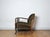 A beautiful patinated vintage Danish lounge chair. The chair features elegantly carved details visible on the wooden...