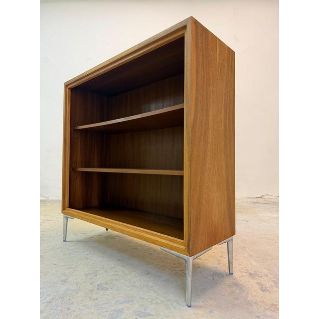 This elegant walnut bookcase from WK Möbel combines the refined aesthetics of mid-century design with a modern, floating...