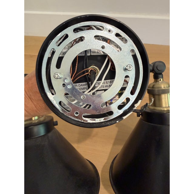 A handsome industrial-style two-light wall sconce by Innovations Lighting featuring two substantial black metal cone...